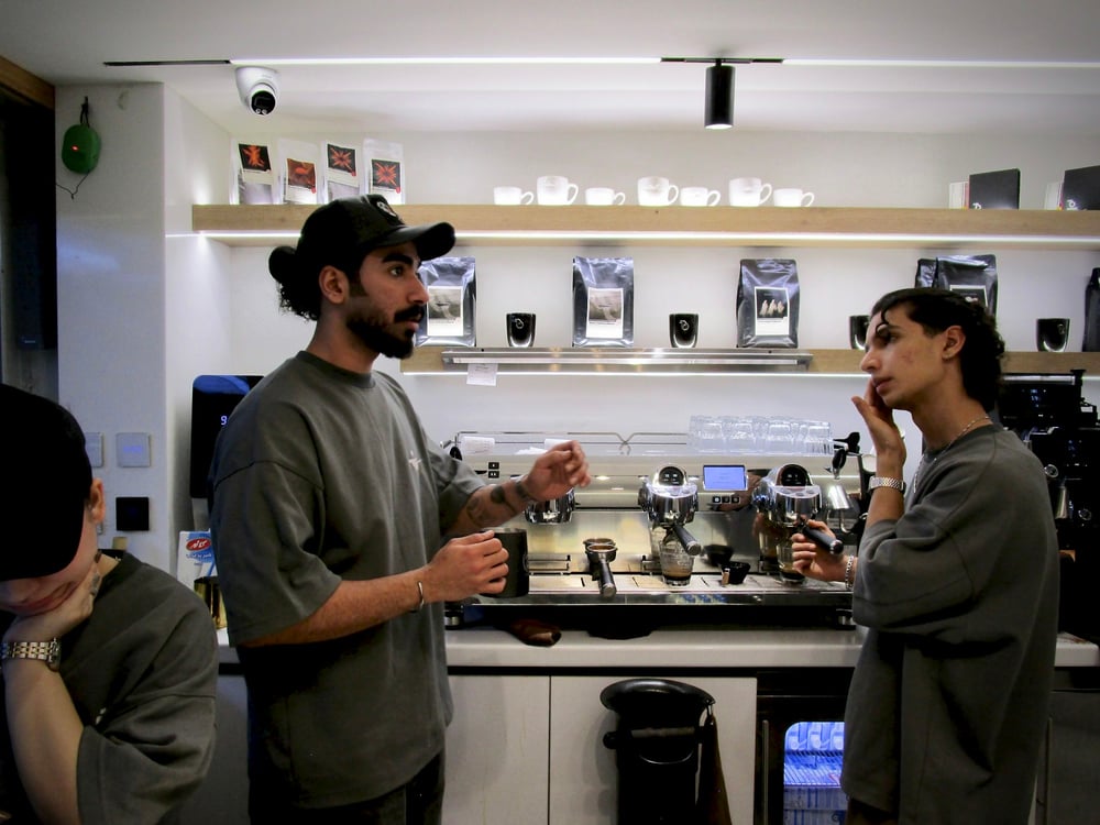 Two people talking across a coffee counter. Photo by Zahra Ahmadpari on Unsplash.