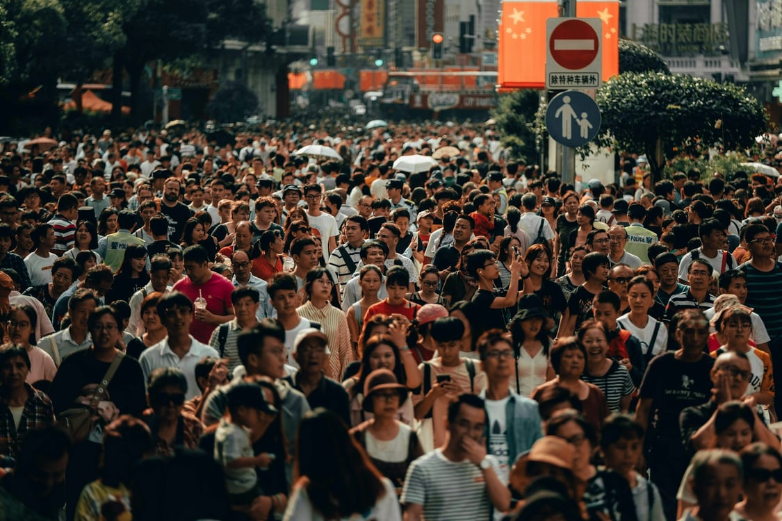 Dense crowd on a city street. Photo by Owen Cannon on Unsplash.