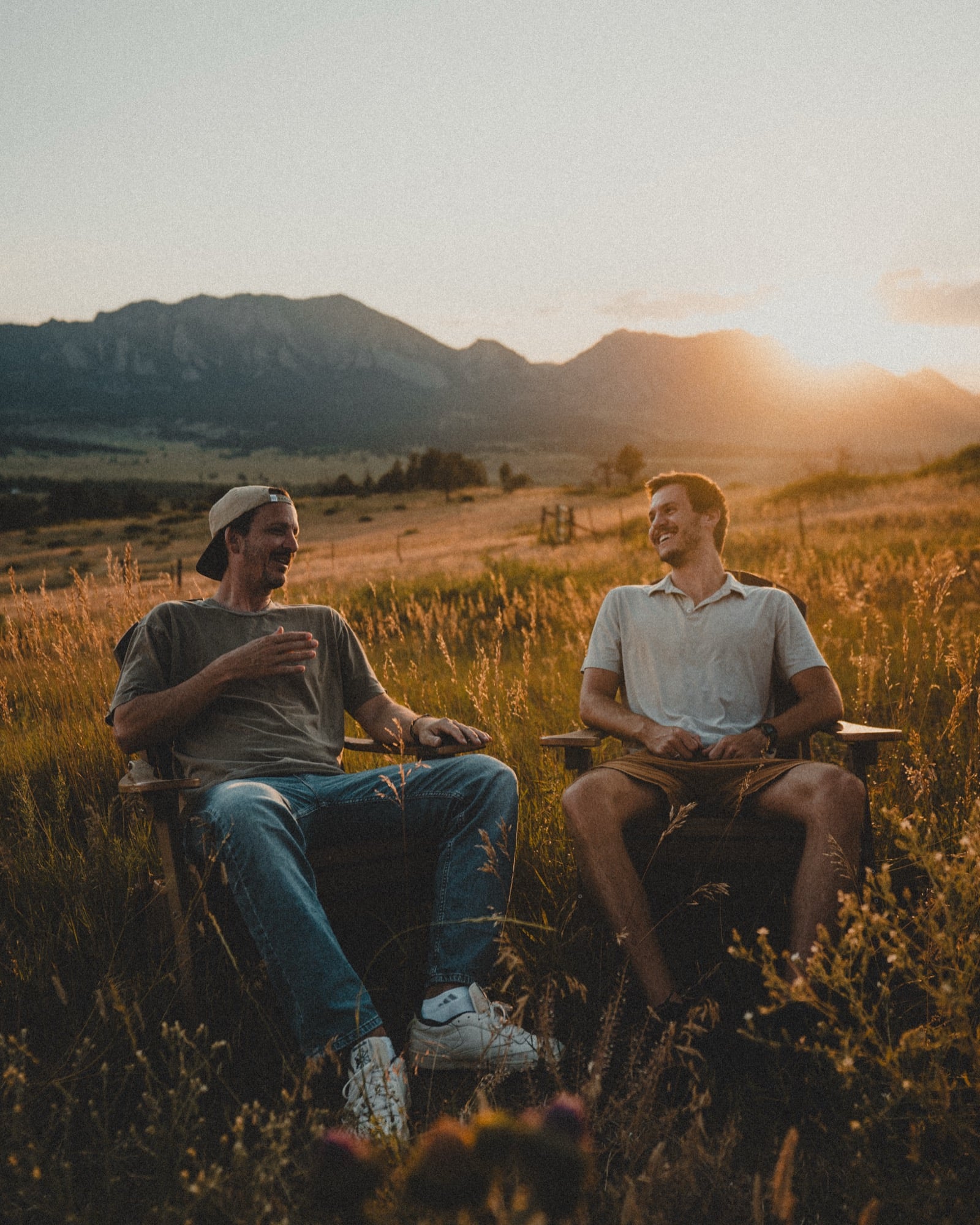 Frelio founders Daniel Norris and Josh Caliguire laughing together in a field at sunset